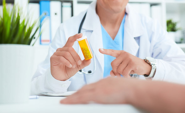 Male doctor hands hold a pill bottle and offer it to visitor. Panacea or life save antidepressant from legal store prescribe vitamin medic aid for healthy lifestyle