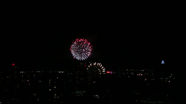 Fireworks bursting at night in Montreal. Viewed from a rooftop.