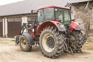 Tractor with hydraulic lift for carrying bales of hay and silage.Photo of a general view of an agricultural machine.The equipment for a dairy farm.
