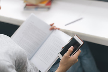 Fototapeta premium Close up Asian woman reading e-book on smartphone in the library..