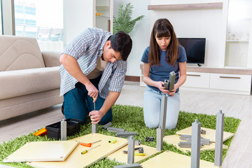 Young family assembling furniture at new house