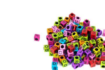 Pile of letter bead or beads with alphabet on white background.