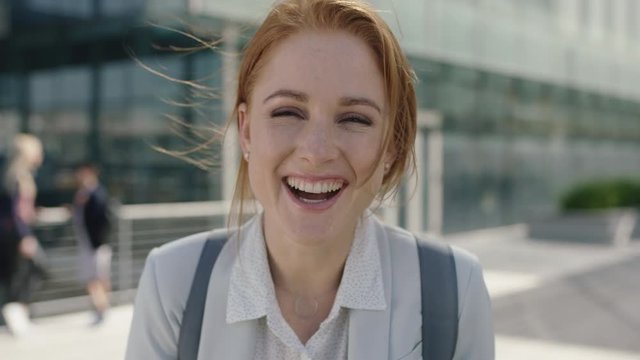 close up portrait of happy red head business woman intern laughing cheerful enjoying corporate career in city