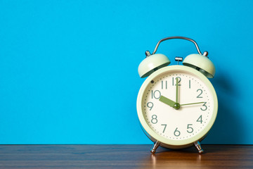 Retro vintage alarm clock on wood table, time concept.