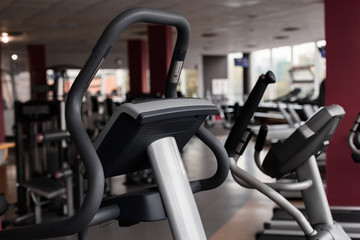 row of two modern new grey and black step machines standing in the gym. concept of sports equipment