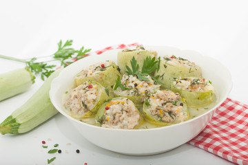 Stuffed zucchini with rice, meat and vegetables in a bowl. White background, homemade healthy cuisine.
