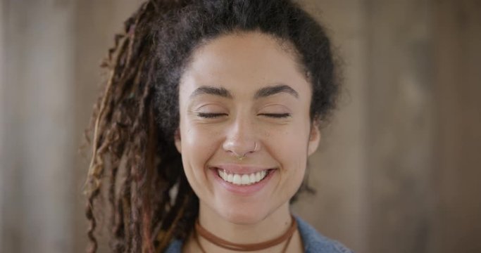 close up portrait of beautiful young mixed race woman smiling happy enjoying successful lifestyle wearing dreadlocks hairstyle independent female slow motion