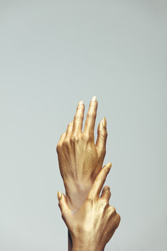 Woman hands painted in gold