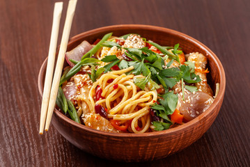 Asian Oriental Cuisine. Japanese noodles with chicken and vegetables, sesame and parsley, in a...