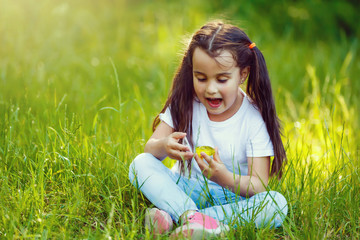 surprised lovely little five-year girl sitting in grass
