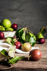 concept of the harvest of autumn and thanksgiving. Seasonal fruit pear and plum on a wooden table in rustic style with copy space