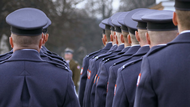 the commander gives awards to soldiers in blue uniform, soldiers stand with their backs to the camera