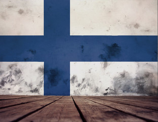 The floor of planks and plastered wall with a painted Finland flag. 
