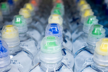 Lid plastic water bottle in the market. multi-colored plastic bottle caps	