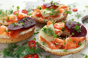 Smoked salmon bagel toasts with soft cheese, cucumber ribbons and beetroot and dill, cress salad