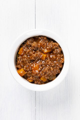 Bolognese sauce. In a white plate. The background is white. Italian food. Copy space. Top view. Vertical shot.