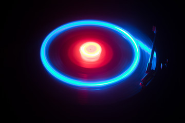 Turntable playing vinyl with glowing abstract lines concept on dark background