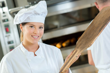 Portrait of chef holding wooden peel