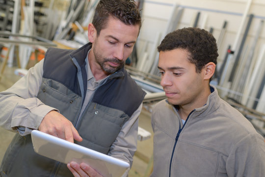 businessman showing digital tablet to co-worker
