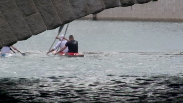A Group of Athletic Men Paddling in Tandem Kayaks Down a River in Malme, Sweden
