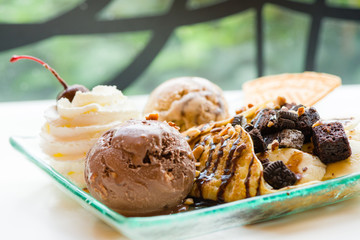 tasty pancakes with chocolate ice cream crispy waffle whipped cream with brownies cherry almond and chocolat syrup on top.served pancakes crepes on plate.sweets dessert brownies pancakes crepes.