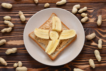 Peanut butter toast with banana slices  on wooden background