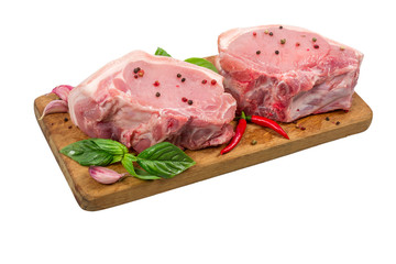 Raw pork meat on wooden cutting board with herbs and spices isolated on white background. cooking concept