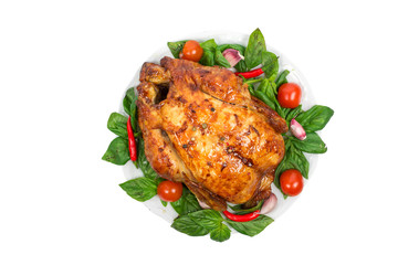 Whole roasted chicken grill on a plate with basil, tomatoes and chili pepper isolated on white background