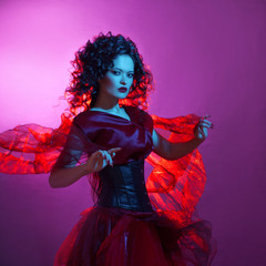 Gothic girl in red. Dancing woman with flying red dress.