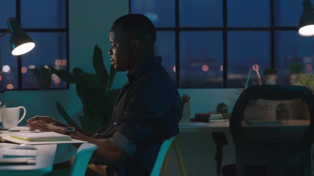 young african american businessman using computer working late night successful entrepreneur busy on company project dedicated black male in start up office workspace