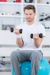 Obraz na płótnie Canvas strong young man doing exercise at home