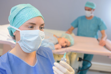 Masked nurse preparing injection