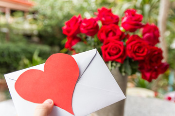 hand holding love letter and red heart