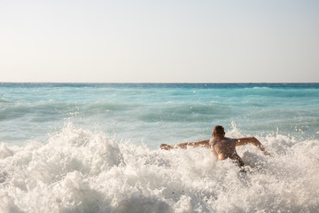 Man chasing the waves on Myrtos beach, island Kefalonia, Greece