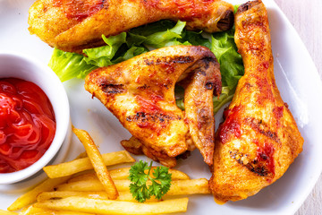 Grilled chicken wings,legs,chips and vegetables