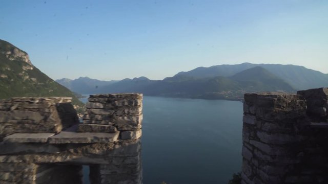 vezio castle, view over the lake and the alps mountains , inside of the old stone castle there are lot of sculpture of gosth