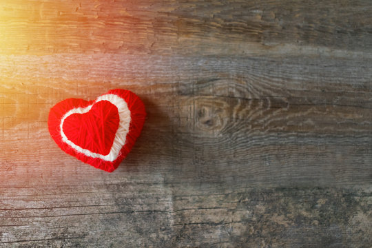 Three Red, white, thread heart on dark wooden vintage background. Handmade pretty heart. Love, romance, Valentines day, wedding, honeymoon, DIY concept. Selective focus