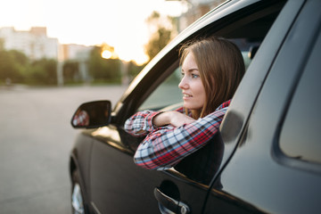 Female driver beginner looks out of the car window