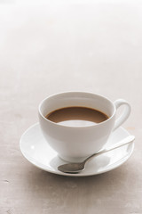 White china cup of tea with milk on a plain background