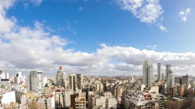 Time-lapse view on the skyline of the city from a balcony of a high rise apartment as Sun breaks through between fast move clouds in Buenos Aires.
