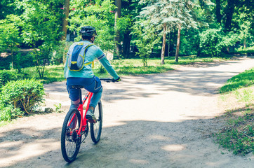 Obraz premium Cyclist in helmet on orange bike riding in park
