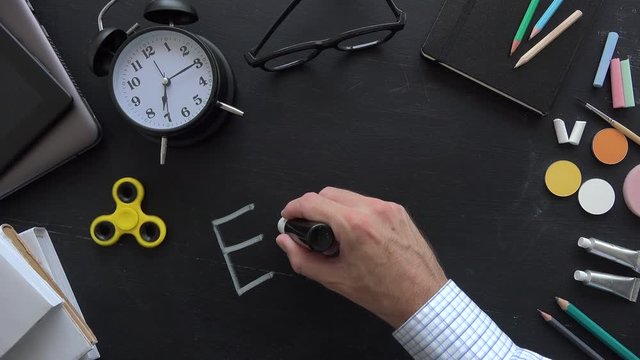 Teacher writing Albert Einsteins physical formula on school blackboard