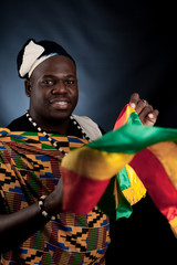 An African man is in national cloth pose and smile on gray background