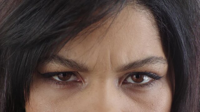 close up hispanic woman eyes frowning looking angry expression wearing makeup cosmetics feminine beauty