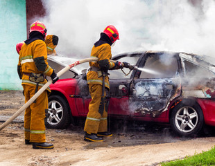 Firefighters extinguish a burning car, fire and car