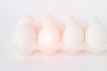 Eggs on white background, one of the eggs is infected with salmonella, close-up, salmonella in the egg