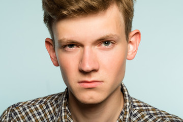 Fototapeta premium blank expression. serious confident man with poker face. portrait of a young guy on light background. emotion facial expression. feelings and people reaction.