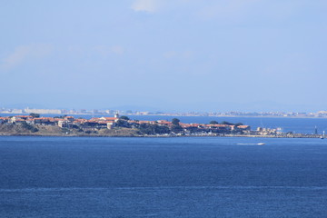 Naklejka na ściany i meble blue sea and sky, a view of the coastal strip with houses and beaches