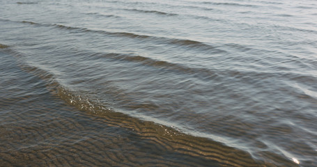 small waves on sandy sea beach on a sunny day