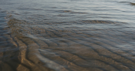 small waves on sandy sea beach on a sunny day